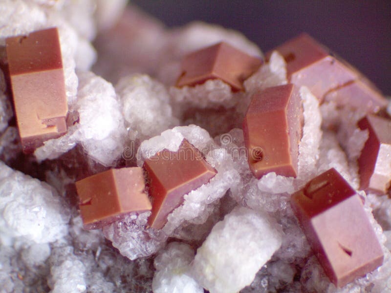 Red vanadinite crystals with calcite from Morocco. 10x blowup of sharp red stubby vanadinite crystals partially coated with calcite from Milbladen, Morocco stock image