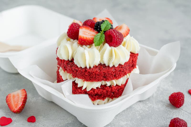 Red velvet bento cake. A small cake in a lunchbox on a gray concrete background. Valentine`s Day Cake. Asian food trend.