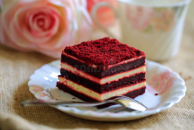 Red velvet cake with beautiful cup of tea on brown cloth background stock photography Red velvet cake with beautiful cup of tea on brown cloth background stock photography