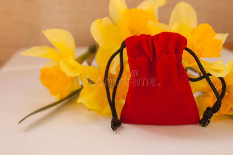Red velvet pouch with yellow flowers on a white background, copy space stock photography Red velvet pouch with yellow flowers on a white background, copy space stock photography