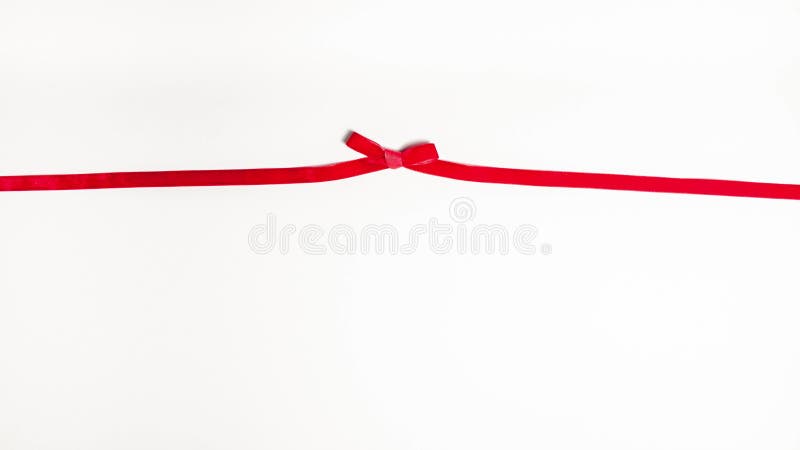 Red velvet ribbon tied in a gift bow on white background with copy space. Stop motion animation holidays and partys concept