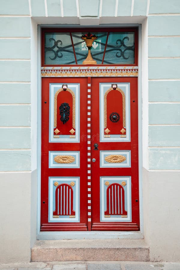 Red vintage door on a old building facade in old Tallinn city