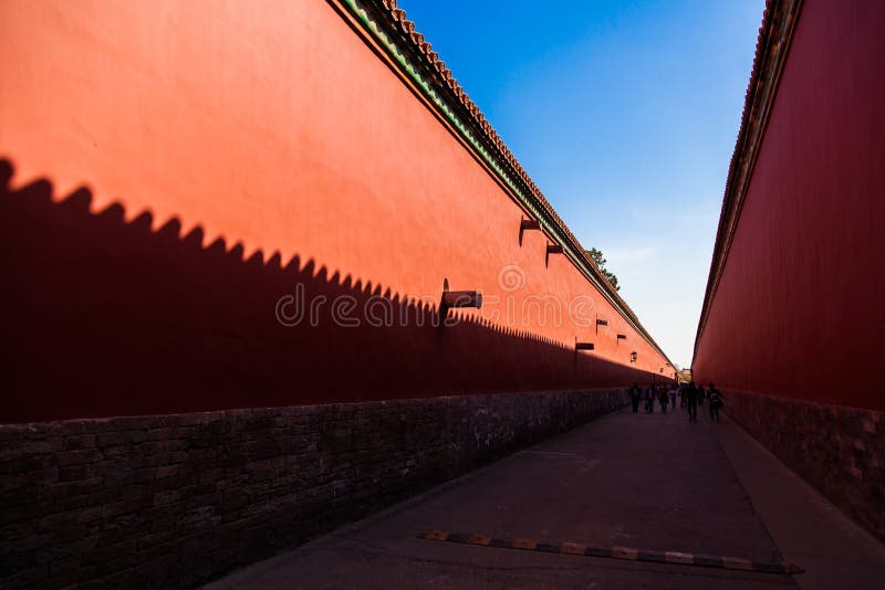 Red walls with yellow tiles on the top on each side of a road in the Forbidden City, Beijing