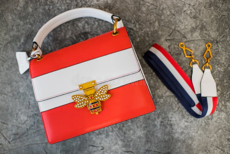 Red white glossy female leather bag on grey background.Top view, women`s accessories. Fashionable elegant stock photography Red white glossy female leather bag on grey background.Top view, women`s accessories. Fashionable elegant stock photography