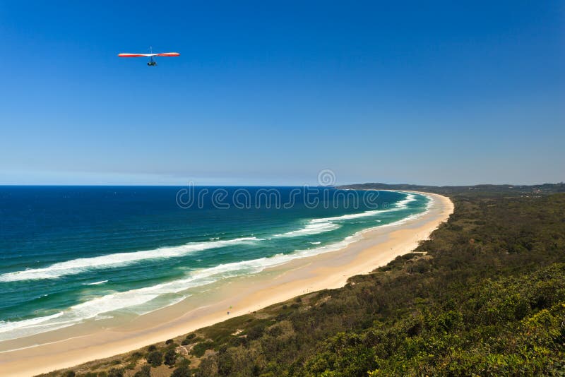 Red and White Hang Glider Above Beautiful Beach