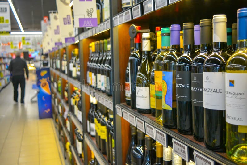 Red and white italian whine on shelves. Wine bottles in grocery store shelf, different colors of labels and quality. Luxury drink