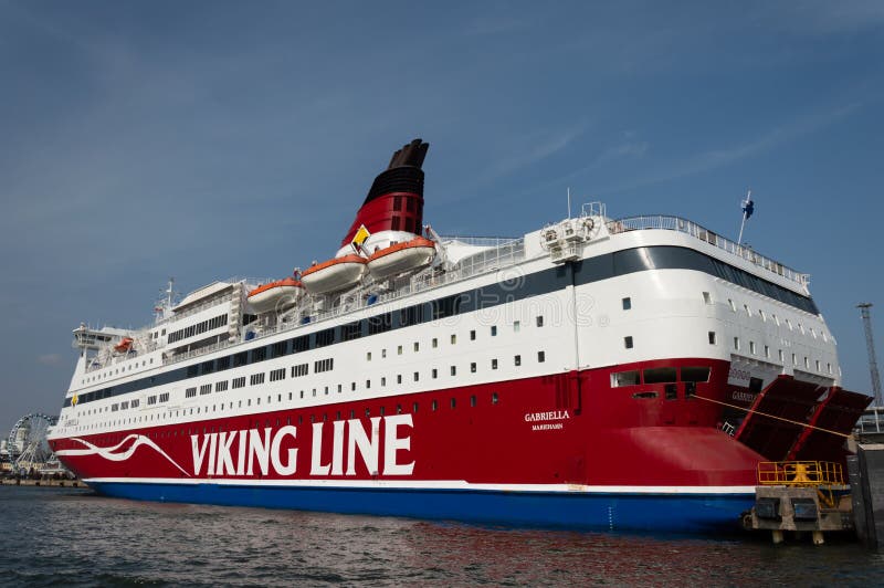 Red and white Viking Line ferry is moored in port.