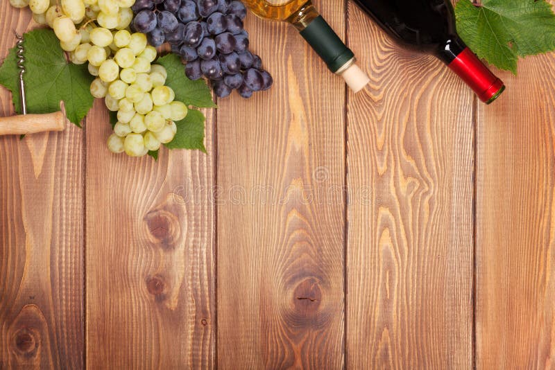 Red and white wine bottles and bunch of grapes royalty free stock images