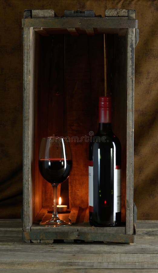 Red wine bottle and glass in wooden box