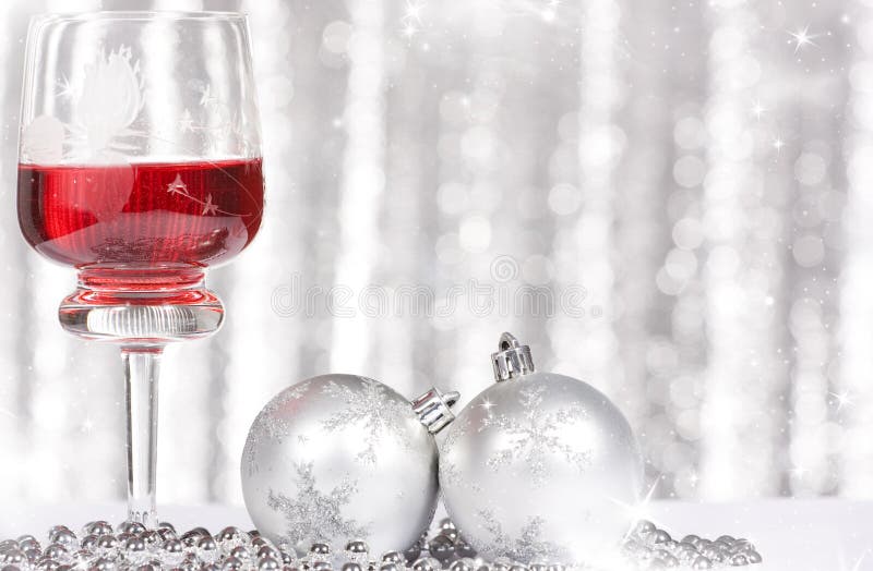 Red wine and Christmas balls against and holiday lights