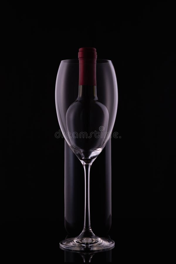 Red Wine Glass and a Wine Bottle with Reflections on Black Background