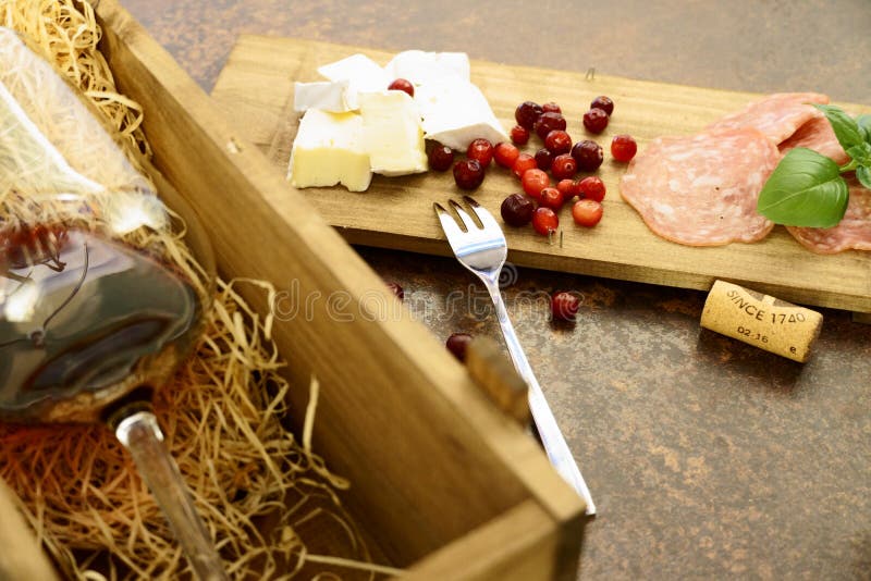 Red wine glass with cheese and salami in wooden box on concrete table stock photo Red wine glass with cheese and salami in wooden box on concrete table stock photo