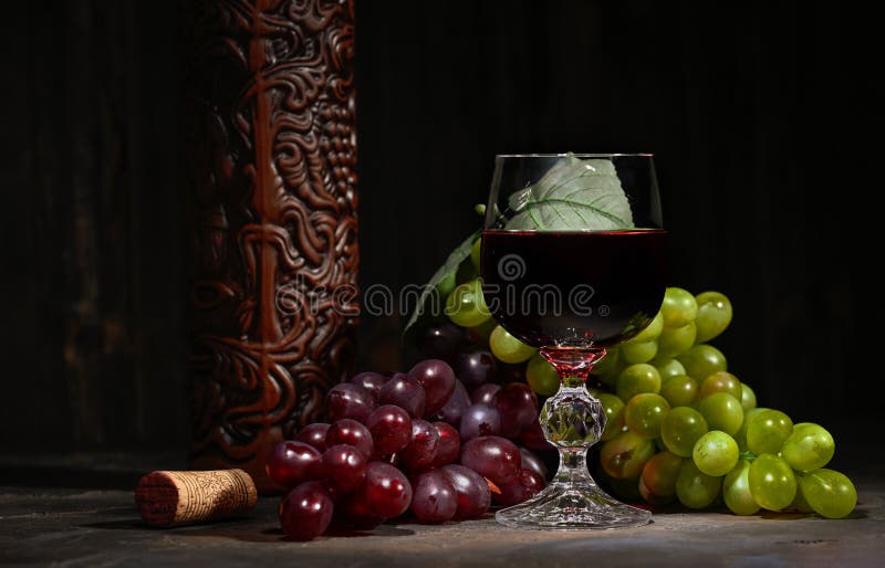 Red Wine in Glass with Vintage Bottle and with Bunch of Red and White