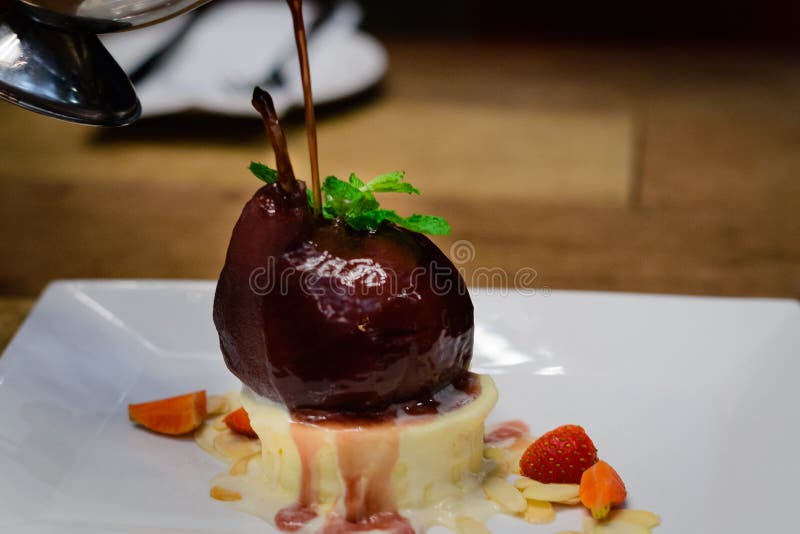 Red Wine Poached Pear with Ice cream and strawberries and mint