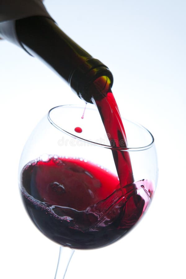 Red wine pouring into wine glass royalty free stock image