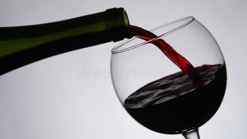 Red wine pouring into wine glass. Close up.