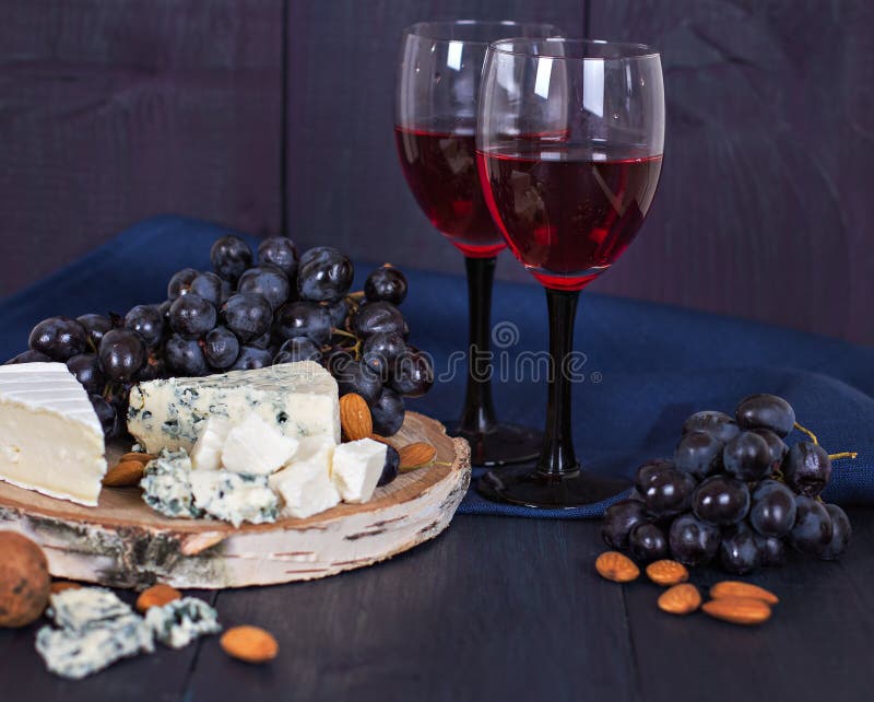 Red wine and snacks. Wine, grapes, cheese, nuts, olives. Romantic evening, still life. royalty free stock image Red wine and snacks. Wine, grapes, cheese, nuts, olives. Romantic evening, still life. royalty free stock image