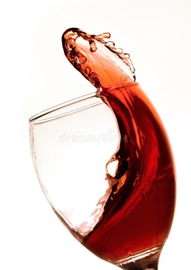 Červené víno skáče a striekajúcej z poháre na víno.