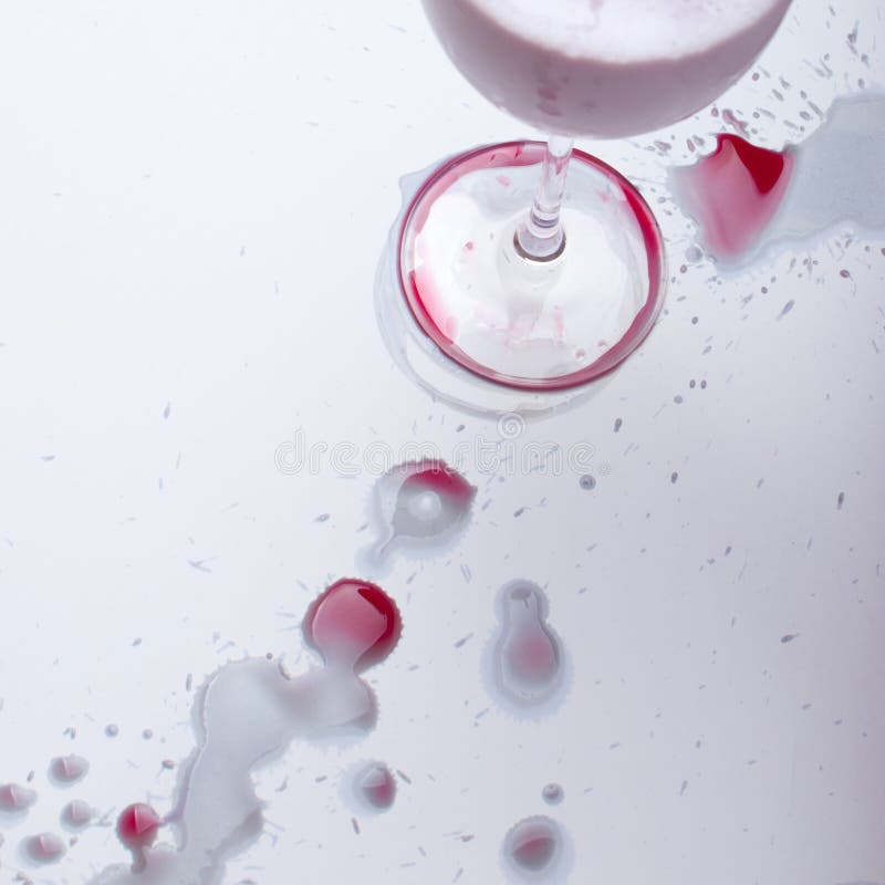 Red Wine Spots on a White Background and a Glass after a Party Stock