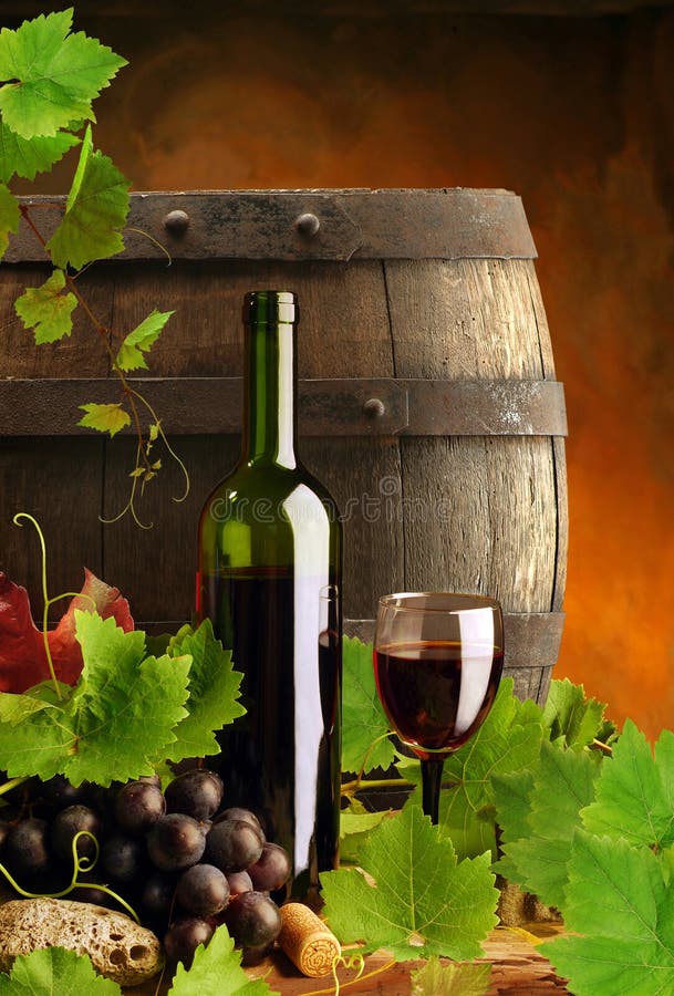 Classico vino rosso, bottiglia, bicchiere e l'uva, su sfondo scuro con canna.