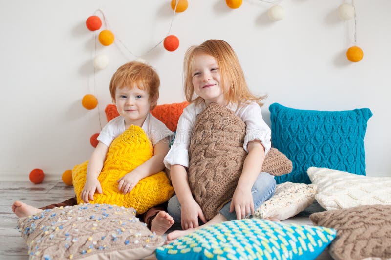 Redhaired Kinder unter Kissen lizenzfreies stockbild Redhaired Kinder unter Kissen lizenzfreies stockbild