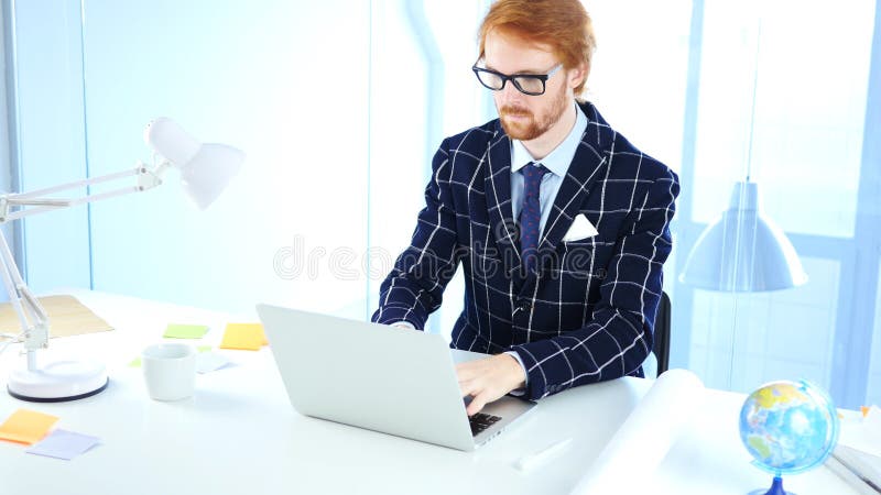 Redhead Businessman Working On Laptop in Office, Creative Freelancer Designer royalty free stock photo Redhead Businessman Working On Laptop in Office, Creative Freelancer Designer royalty free stock photo