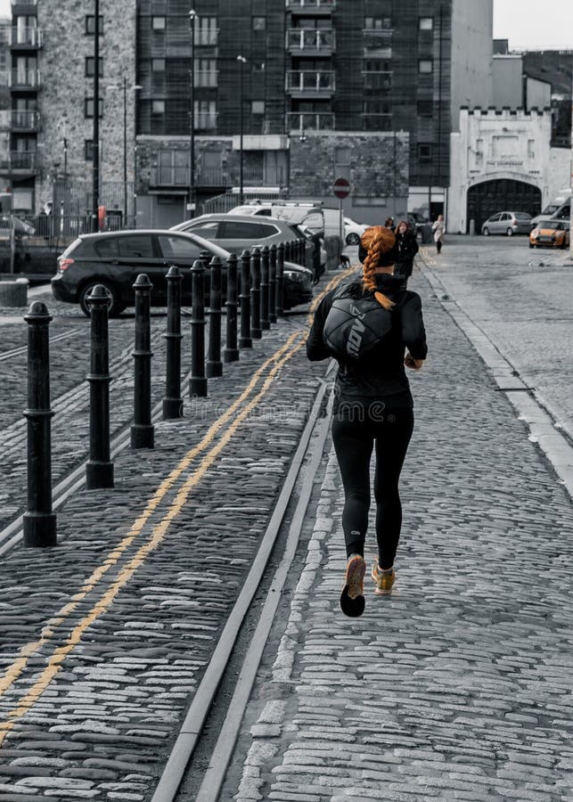 Redhead/Ginger Woman Running on Cobked Street at Plymouth Barbican royalty-vrije stock afbeeldingen Redhead/Ginger Woman Running on Cobked Street at Plymouth Barbican royalty-vrije stock afbeeldingen