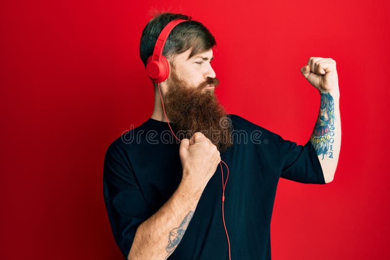 Redhead Man with Long Beard Listening To Music Using Headphones Showing