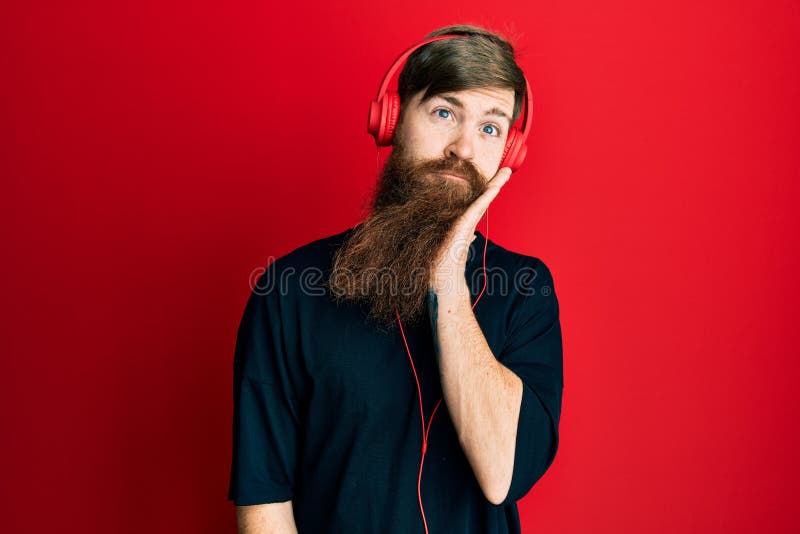Redhead Man with Long Beard Listening To Music Using Headphones ...