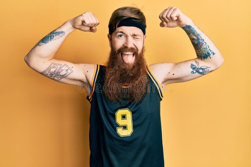 Redhead Man with Long Beard Wearing Basketball Uniform Showing Muscles