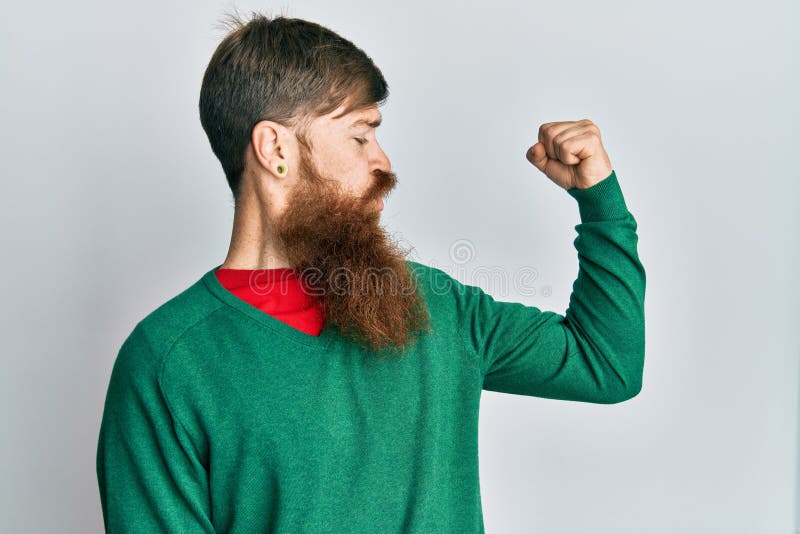 Redhead Man with Long Beard Wearing Casual Clothes Showing Arms Muscles