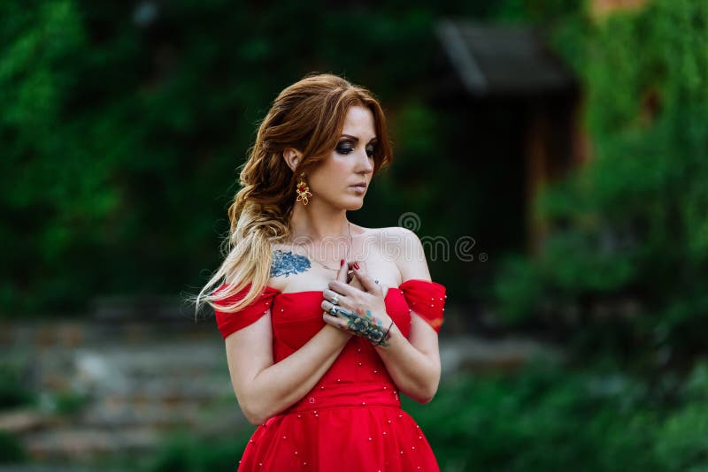 Redhead woman in red dress near the castle stock photography Redhead woman in red dress near the castle stock photography