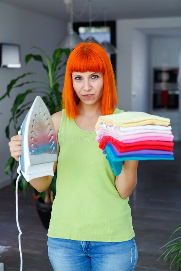 Redhead woman ironing clothes at home royalty free stock photos Redhead woman ironing clothes at home royalty free stock photos