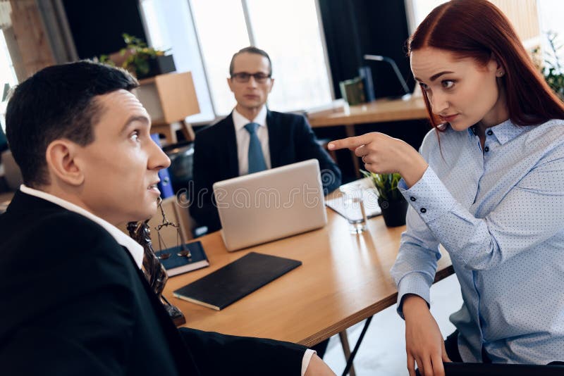 Redheaded angry women argues with adult men in divorce lawyer`s office. Adult couple gets divorced from attorney for divorce in office. Redheaded angry women argues with adult men in divorce lawyer`s office. Adult couple gets divorced from attorney for divorce in office.