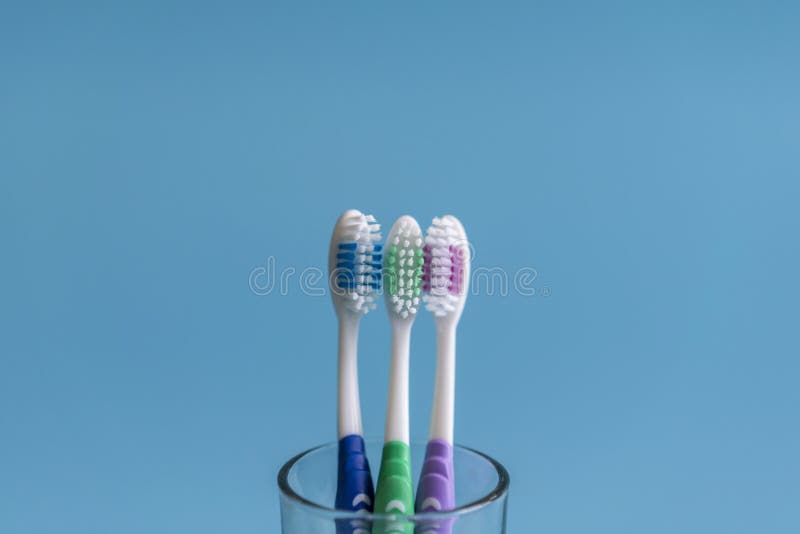 Reeks tandenborstels in glas op blauwe achtergrond Kop met tandenborstels tegen kleurenachtergrond Tand zorg royalty-vrije stock foto Reeks tandenborstels in glas op blauwe achtergrond Kop met tandenborstels tegen kleurenachtergrond Tand zorg royalty-vrije stock foto