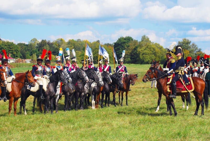 Reenactors dressed as Napoleonic war French soldiers ride horses royalty free stock images