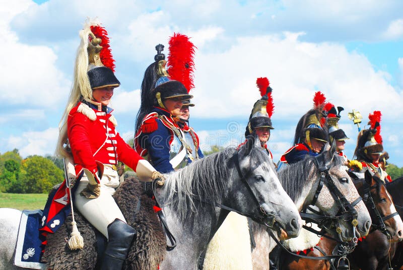 Reenactors dressed as Napoleonic war soldiers ride horses royalty free stock photography