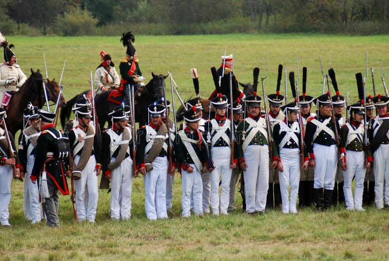 Reenactors dressed as Napoleonic war soldiers stand holding guns stock image