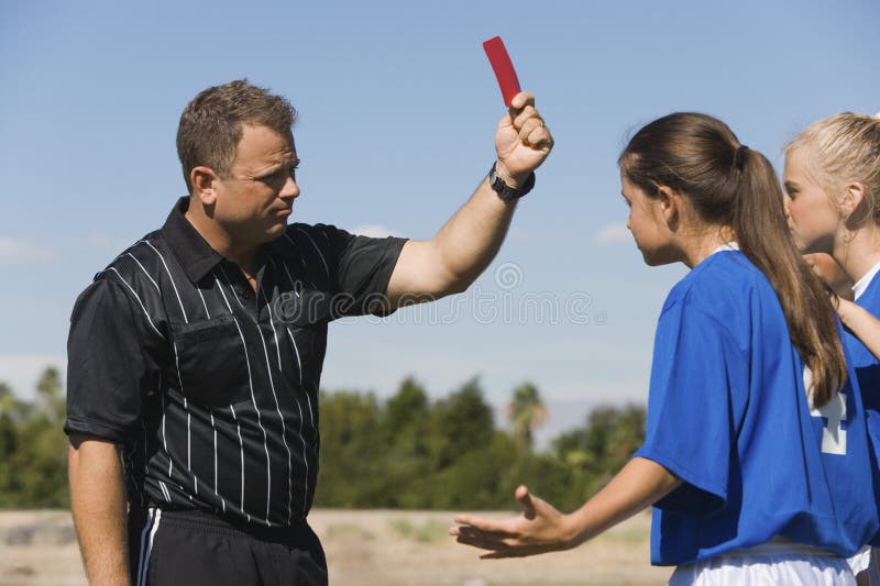 Referee showing red card to girls playing soccer