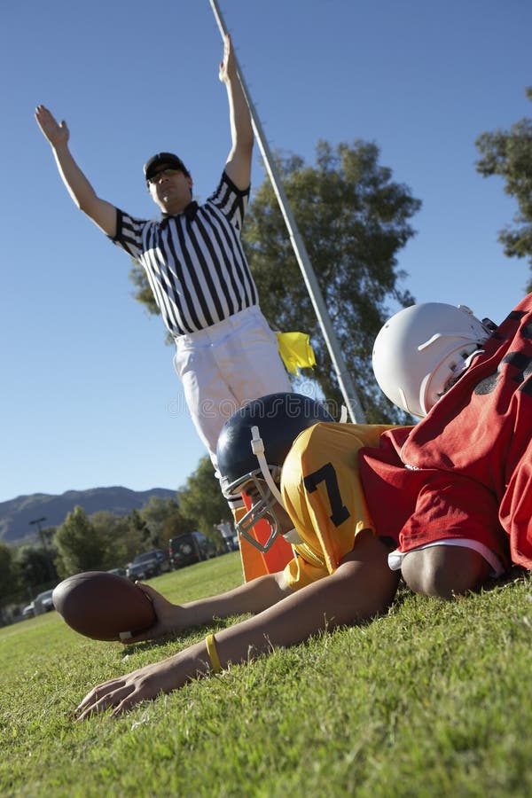 Referee signalling touchdown over football player