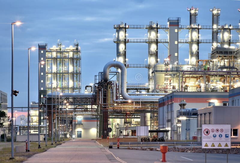 Refinery - chemical factory at night with buildings, pipelines and lighting - industrial plant