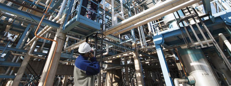 Refinery worker, engineer pointing at large oil and gas installation. Refinery worker, engineer pointing at large oil and gas installation