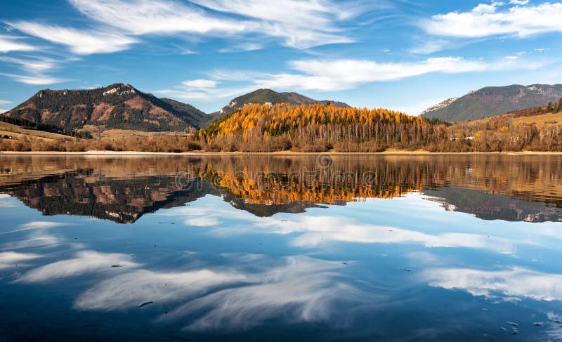 Reflection of autumn trees and hills on water surface. Dam Liptovska Mara at Slovakia