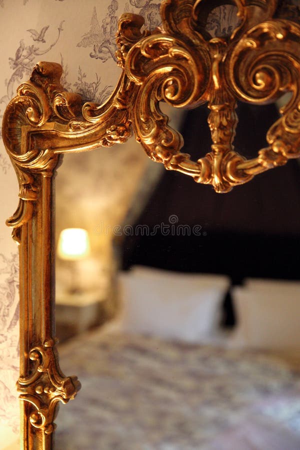 Reflection of a bed in a gold vintage mirror stock photography