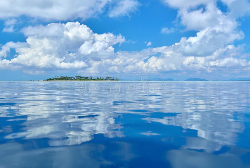 Reflection of clouds on calm and tranquil ocean