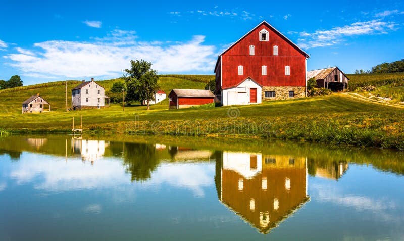 Reflection of house and barn in a small pond, in rural York County, Pennsylvania.