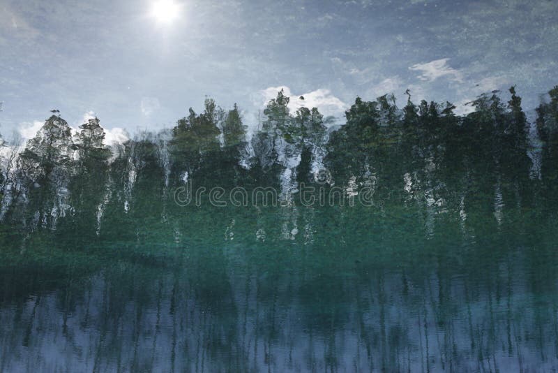 Reflektiert im Wasser mit Kräuselungen gestalten Sie, Wald, Himmel landschaftlich stockfotos Reflektiert im Wasser mit Kräuselungen gestalten Sie, Wald, Himmel landschaftlich stockfotos