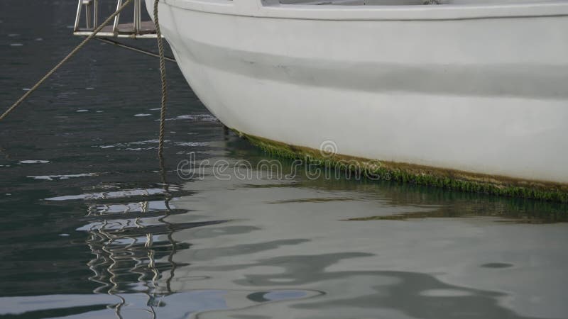 Reflet à la surface de la mer de yachts blancs garés dans le port sur le rivage. fragment d'un navire sur l'eau et le