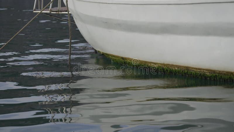 Reflet à la surface de la mer de yachts blancs garés dans le port sur le rivage. fragment d'un navire sur l'eau et le