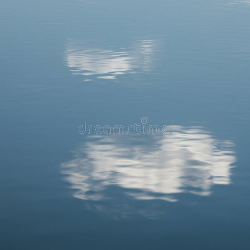 Reflexiile norilor albi pe suprafața apei albastre calme creează o senină moale royalty free illustration